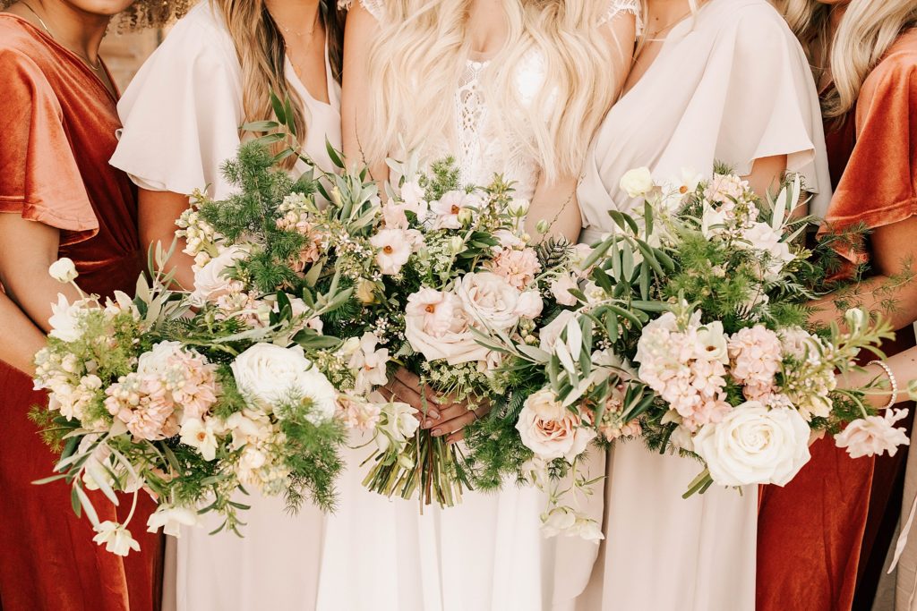 bridesmaids holding gorgeous floral bouquets standing side by side at an idaho falls wedding venue