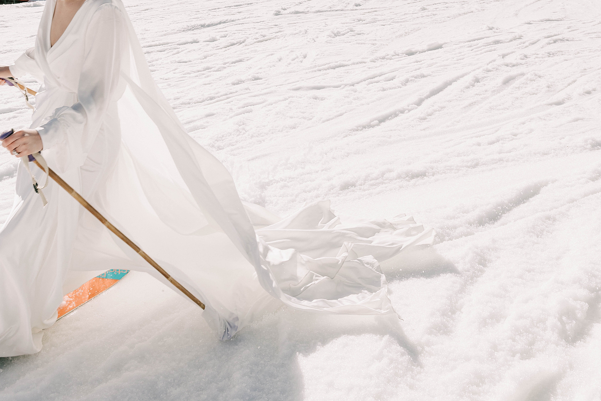 a bride skiing down the mountain after her jackson hole mountain resort wedding taken by local photographer adrian wayment.