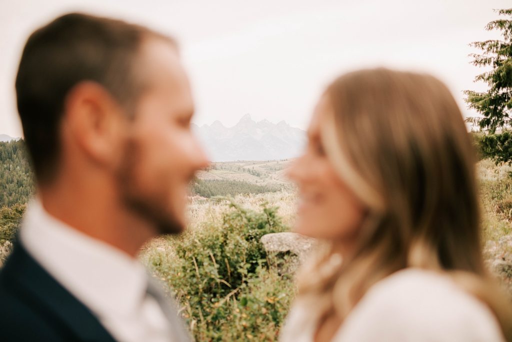 tetons in the background of bride and groom after their snake river ranch wedding ceremony taken by adrian wayment photo
