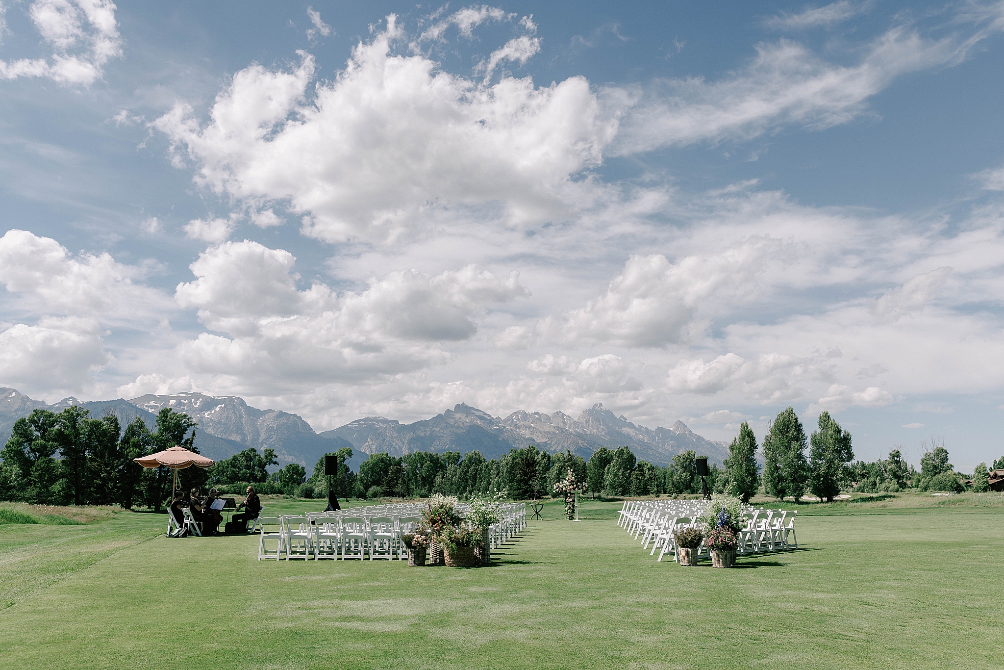 a wedding ceremony scene at a jackson hole golf and tennis club wedding taken by local wedding photographer adrian wayment.