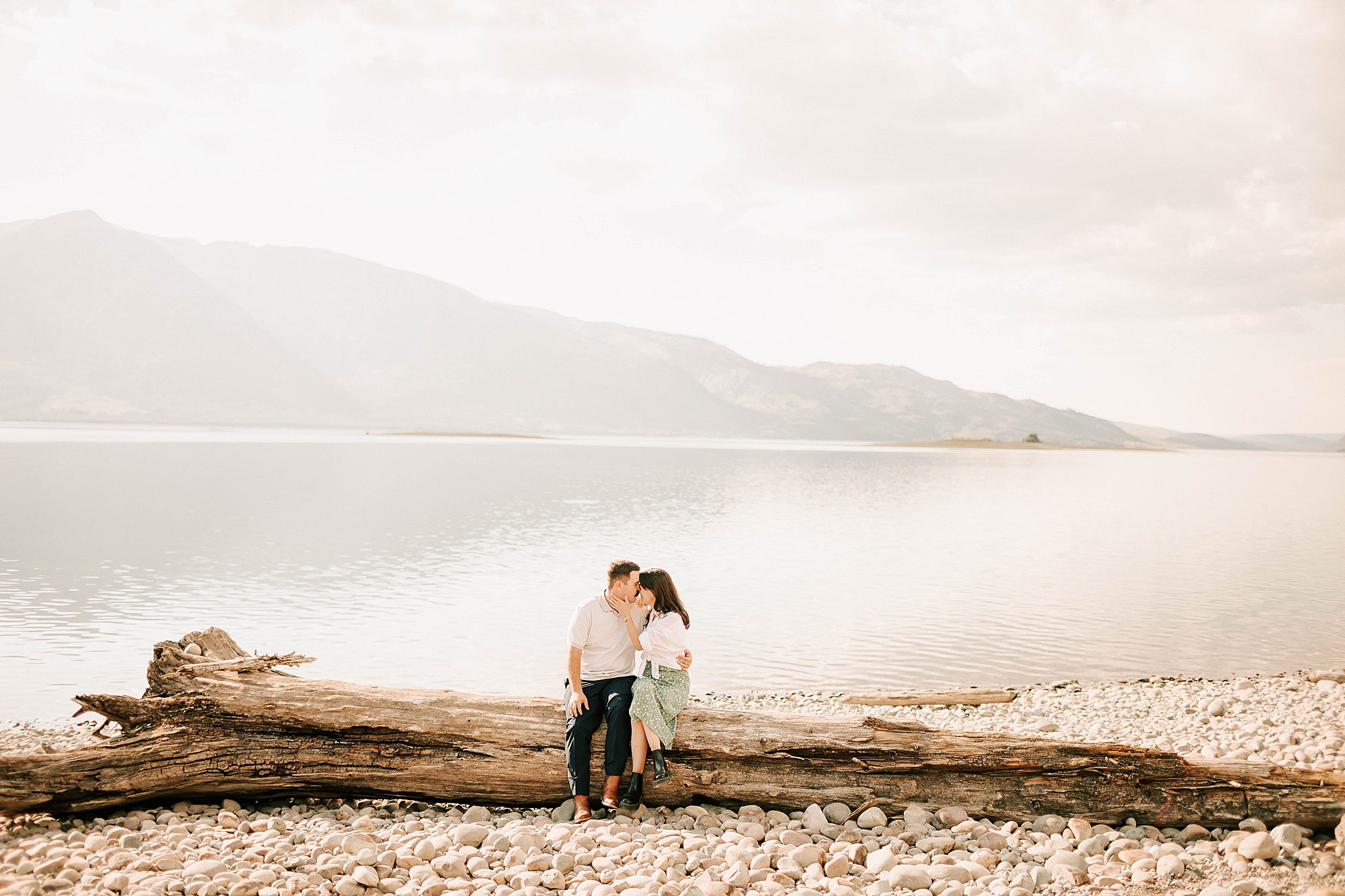 engaged couple kissing on a log near jenny lake lodge taken by photographer adrian wayment photo