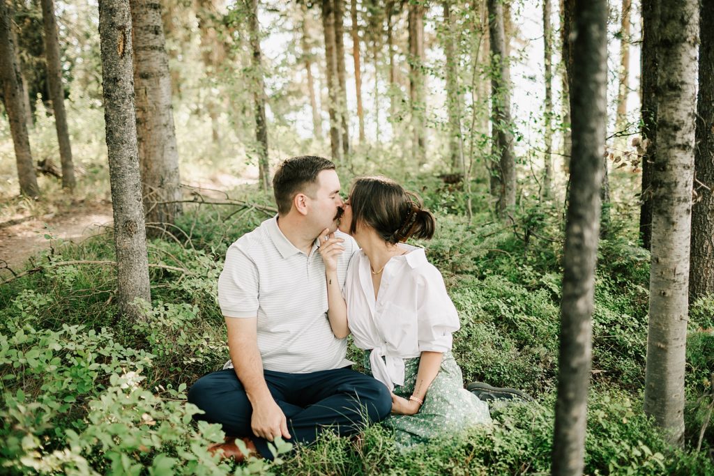 boy and girl kissing in the huckleberry patch near jenny lake lodge taken by photographer adrian wayment photo