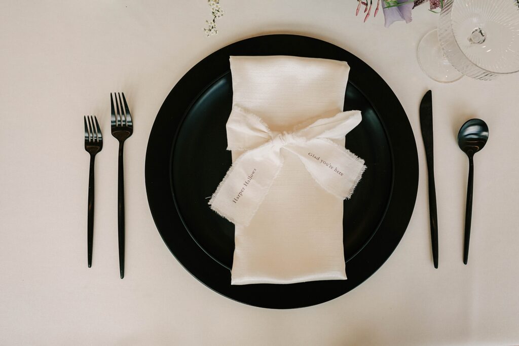 tablescape detail, including forks, spoon, knife, napkin and plate at a twenty and creek wedding.
