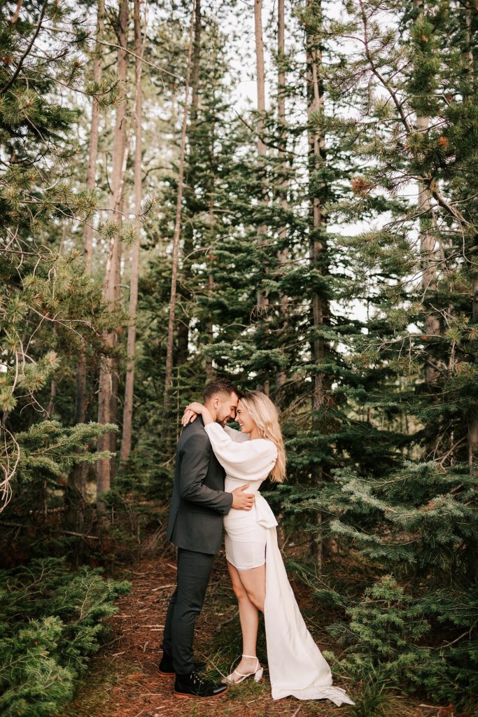 bride and groom in the pine trees at stringhead lake after their grand teton elopement taken by adrian wayment photo
