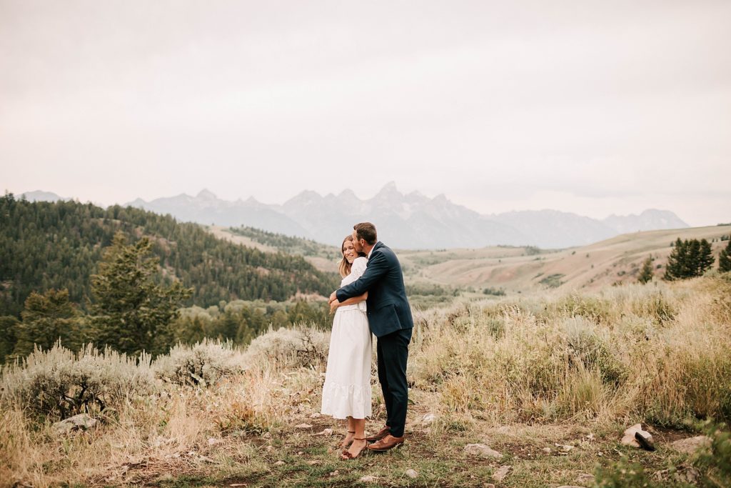 bride and groom standing near the wedding tree for their grand teton elopement hugging each other taken by adrian wayment photo
