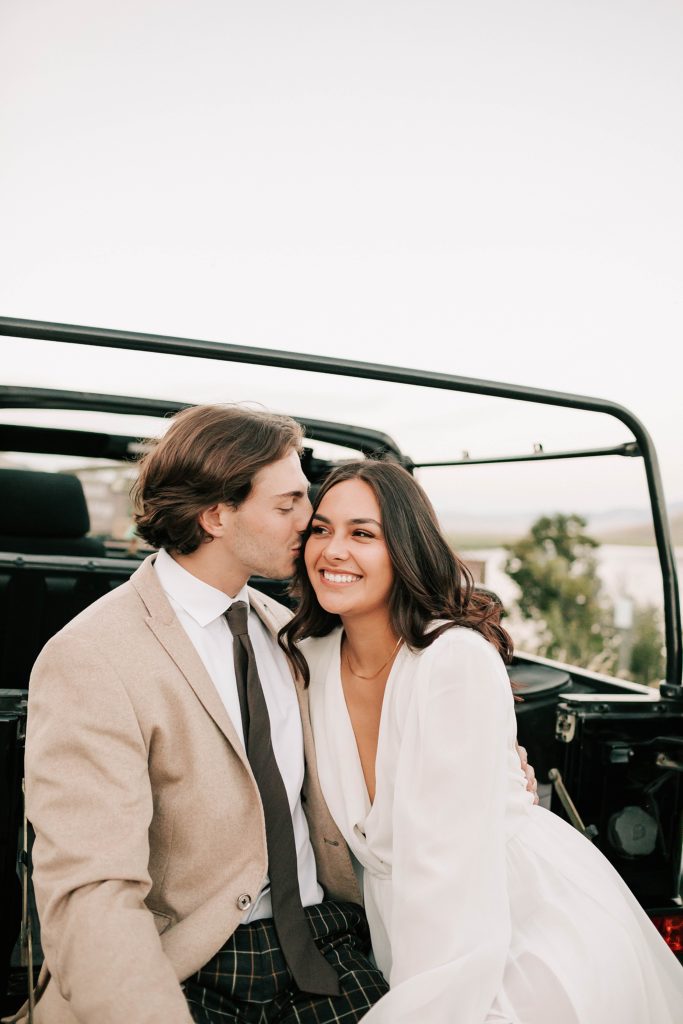 bride smiling while groom kisses her temple after their cloudveil wedding in jackson hole.