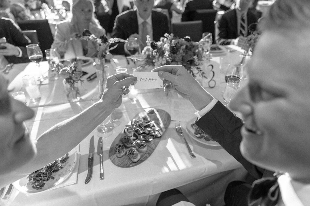 bride and groom sitting at their table for dinner looking at each other at their cloudveil jackson hole wedding. photo taken by adrian wayment.