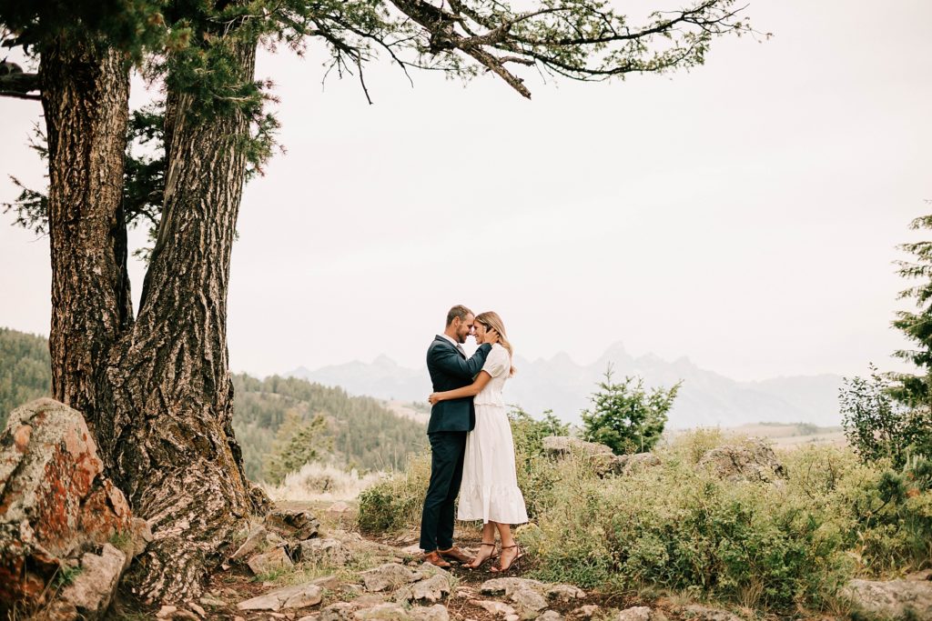 bride and groom holding each other after their wedding tree elopement outside of grand teton national park taken by adrian wayment photo