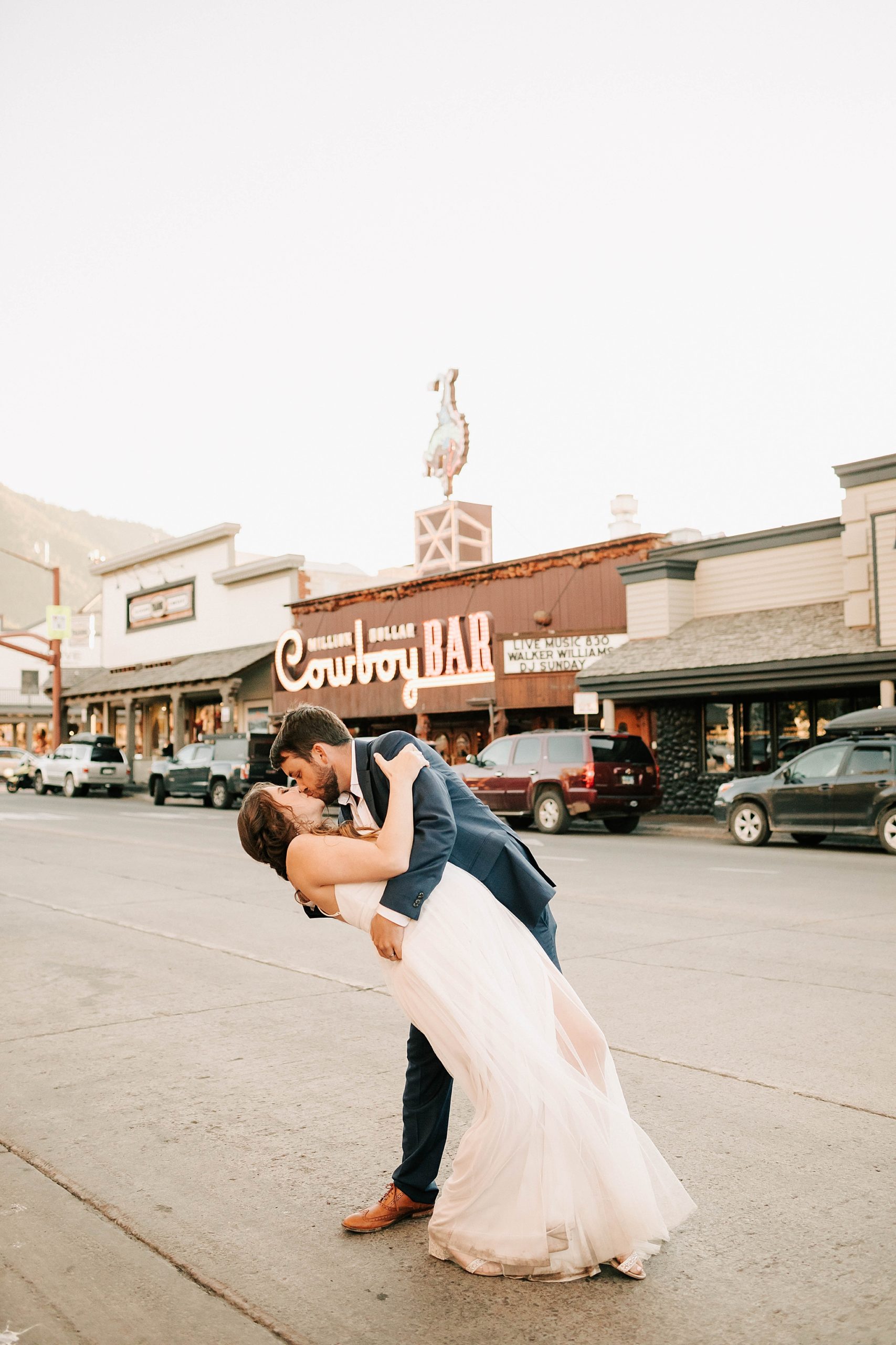 bride and groom kissing in front of the cowboy bar after their intimate wedding at Moulton Barn.