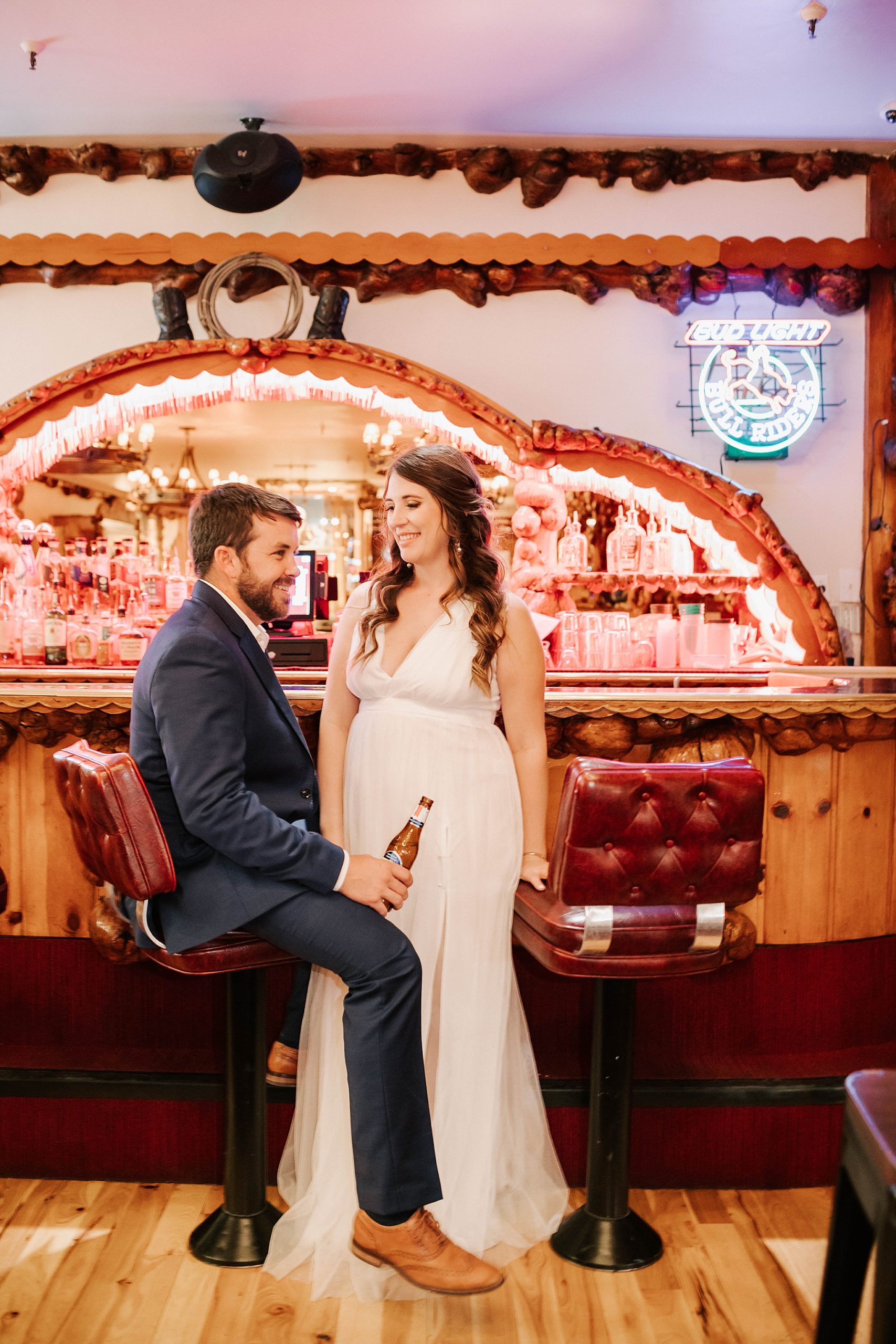 bride and groom in the Cowboy Bar grabbing a drink in their wedding clothes after their Moulton Barn wedding.