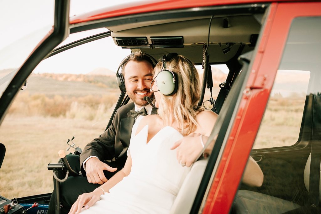 bride and groom in helicopter after their split creek ranch wedding taken by adrian wayment photo.