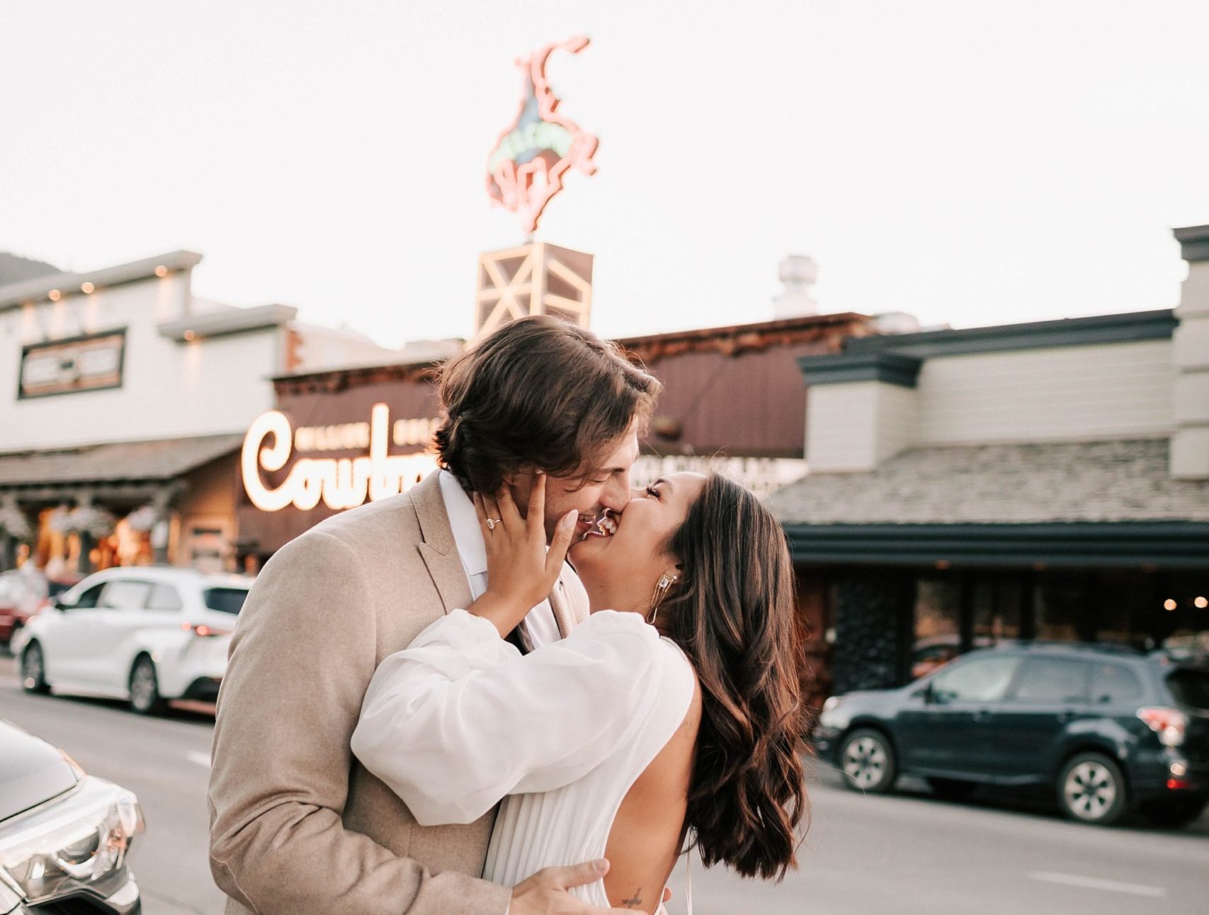 bride and groom kissing outside of the million dollar cowboy bar after their wedding.